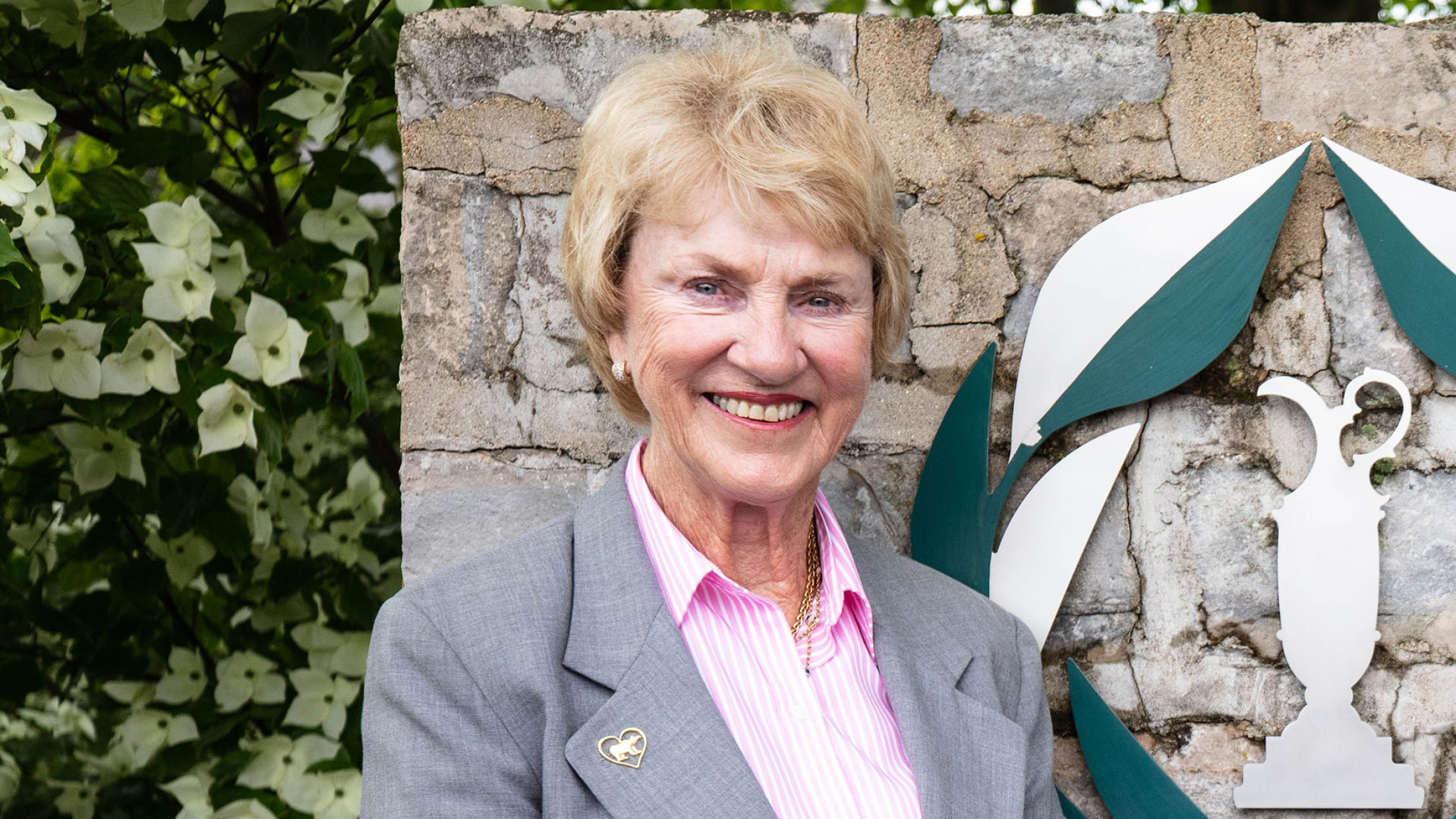 Barbara Nicklaus posing in front of the memorial tournament logo